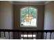 Stairwell with chandelier, crown molding, and a large arched window offering natural light at 9342 Carillon Ct, Jonesboro, GA 30236