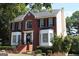 A two-story brick home with a manicured lawn and landscaped garden at 9342 Carillon Ct, Jonesboro, GA 30236