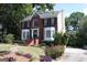 Charming brick home with a manicured lawn, flowering bushes, and mature trees at 9342 Carillon Ct, Jonesboro, GA 30236