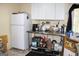 Kitchen features a white refrigerator, stainless steel tables and white cabinets at 9342 Carillon Ct, Jonesboro, GA 30236