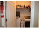 Laundry room with white appliances including a washer and dryer, and a fire extinguisher at 9342 Carillon Ct, Jonesboro, GA 30236
