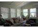 Bright living room features a cozy sofa, multiple windows, and comfortable seating at 9342 Carillon Ct, Jonesboro, GA 30236