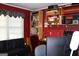 Office room with a large desk, a futon, red walls and wooden shelves at 9342 Carillon Ct, Jonesboro, GA 30236