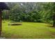 Tranquil backyard with a trampoline, lush green lawn, and surrounding trees, offering a serene and private outdoor space at 69 Trace Ct, Stockbridge, GA 30281