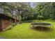 Picturesque backyard featuring a lush lawn, mature trees, and a trampoline, ideal for outdoor enjoyment and recreation at 69 Trace Ct, Stockbridge, GA 30281