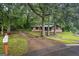 Exterior shot of home, featuring a long driveway leading up to a stone and wood-clad house surrounded by trees at 69 Trace Ct, Stockbridge, GA 30281