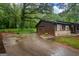View of a garage with stone accents and a basketball hoop, set beside a charming home with a welcoming front porch at 69 Trace Ct, Stockbridge, GA 30281