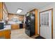 Kitchen with black appliances, wooden cabinets, and neutral countertops, complemented by wood-look flooring at 69 Trace Ct, Stockbridge, GA 30281