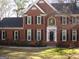 Charming two-story red brick home with black shutters and a well-maintained lawn on a sunny day at 155 Glenwood Ln, Fayetteville, GA 30215