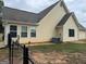 Home exterior featuring light yellow siding, a fenced backyard, and a visible air conditioning unit at 521 Deadwood Trl, Locust Grove, GA 30248