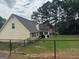 Fenced backyard featuring a small patio area with a grill and a fire pit at 521 Deadwood Trl, Locust Grove, GA 30248