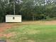 Fenced backyard featuring a storage shed, a grassy area, and a small tree line at 521 Deadwood Trl, Locust Grove, GA 30248