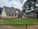 Landscaped backyard featuring a patio area with furniture, a grill, a fire pit, and a fence at 521 Deadwood Trl, Locust Grove, GA 30248