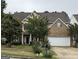 Charming two-story home with a brick facade and attached two-car garage at 12402 Muir Field Ct, Fayetteville, GA 30215