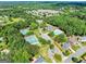 Aerial view of a community showcasing tennis courts, a swimming pool, and tree-lined streets at 1504 Oglethorpe Dr, Suwanee, GA 30024