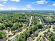Expansive aerial view of a residential community surrounded by lush greenery and blue skies at 1504 Oglethorpe Dr, Suwanee, GA 30024