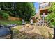 Backyard featuring a stone fire pit and mature trees offer a cozy outdoor space at 1504 Oglethorpe Dr, Suwanee, GA 30024