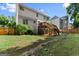 Fenced backyard with a multilevel wooden deck and mature trees at 1504 Oglethorpe Dr, Suwanee, GA 30024