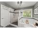 Bathroom featuring a glass-enclosed shower, soaking tub, and a window offering natural light at 1504 Oglethorpe Dr, Suwanee, GA 30024