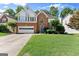 Charming two-story brick home with a two-car garage and a well-manicured lawn at 1504 Oglethorpe Dr, Suwanee, GA 30024