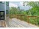 Expansive wooden deck with natural wood railings, offers outdoor space with views of a lush wooded area at 5490 Bent Grass Way, Douglasville, GA 30135