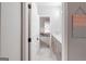 Bright hallway leading to a bathroom with dual sinks and modern grey cabinetry at 5490 Bent Grass Way, Douglasville, GA 30135