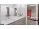 Bright bathroom featuring a double vanity with quartz countertop and a glimpse into an adjacent bedroom at 5490 Bent Grass Way, Douglasville, GA 30135