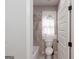 Bathroom showcasing toilet, tub/shower with white and grey accents and privacy window at 5490 Bent Grass Way, Douglasville, GA 30135