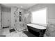 Elegant bathroom featuring a freestanding tub, modern shower, and marble tile at 5490 Bent Grass Way, Douglasville, GA 30135