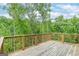 A spacious wooden deck with trees in the background is ideal for outdoor relaxation at 5490 Bent Grass Way, Douglasville, GA 30135