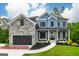 Two-story blue home with stone accents, manicured lawn, and inviting front porch at 5490 Bent Grass Way, Douglasville, GA 30135