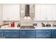A kitchen featuring granite countertops, white upper cabinets, and dark blue lower cabinets with stainless steel appliances at 5490 Bent Grass Way, Douglasville, GA 30135