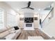 Stylish living room with fireplace, mounted TV, hardwood flooring, a cozy sectional, and a ceiling fan at 5490 Bent Grass Way, Douglasville, GA 30135