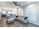 Spacious living room features hardwood floors, a fan, and a large sectional sofa with a view into the kitchen at 5490 Bent Grass Way, Douglasville, GA 30135