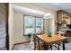 Bright dining area with a wooden table, plants, and a large window overlooking the yard at 55 Helen Ln, Stockbridge, GA 30281