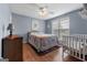 Comfortable bedroom with ceiling fan, hard wood floors, double window, crib and a quilt-covered bed at 1112 Haver Ct, Mcdonough, GA 30252
