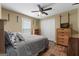 Well-lit bedroom featuring hardwood floors, a ceiling fan, closet, dresser, and a comfortable bed with stylish bedding at 1112 Haver Ct, Mcdonough, GA 30252