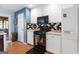 Kitchen featuring white cabinets, black appliances, a decorative tile backsplash and wood flooring at 1112 Haver Ct, Mcdonough, GA 30252