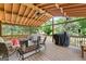 Covered outdoor patio with wood flooring, ceiling fan, an outdoor kitchen and wooded views at 1112 Haver Ct, Mcdonough, GA 30252