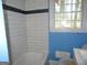 Cozy bathroom featuring white tiled walls, a contrasting dark blue accent wall, and a tub at 1876 Sw Sandtown Sw Rd, Atlanta, GA 30311