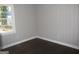 Cozy bedroom with wood-paneled walls and hardwood floors, illuminated by natural light from a window at 1876 Sw Sandtown Sw Rd, Atlanta, GA 30311