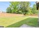 Spacious backyard featuring a wooden fence, lush green grass, and a charming garden bed at 548 Thomas Downs Way, Jonesboro, GA 30238