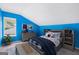 Stylized bedroom features vibrant blue walls, a playful bed, and a street-view window at 548 Thomas Downs Way, Jonesboro, GA 30238