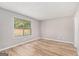 Bright bedroom featuring wood-look flooring and a large window with backyard view at 548 Thomas Downs Way, Jonesboro, GA 30238