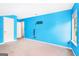 Empty bedroom featuring vibrant blue walls, two doors, and a street-view window at 548 Thomas Downs Way, Jonesboro, GA 30238