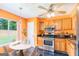 Open-concept kitchen with a small eating area, stainless steel appliances, and vibrant orange walls at 548 Thomas Downs Way, Jonesboro, GA 30238