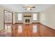 Spacious living room featuring a stone fireplace, ceiling fan and laminate flooring, with view of another room at 175 Laney Ct, Mcdonough, GA 30252