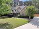 A daylight view of this home with well-maintained lawn, landscaping, and curved driveway at 204 Carmell Ct, Mcdonough, GA 30252