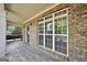 Inviting covered front porch with wood-look tile, brick accents, and ample natural light at 204 Carmell Ct, Mcdonough, GA 30252