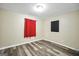 Bright bedroom with wood-look flooring, neutral walls, and a window with red curtains at 758 King Rd, Jonesboro, GA 30236